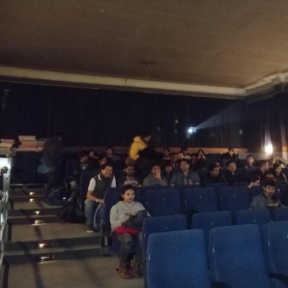A movie theatre with people watching a movie.